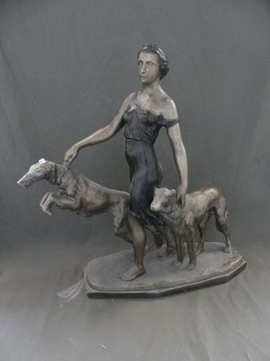 statue représentant une femme avec deux chiens et un chat sur un plateau