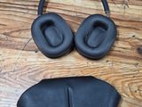an image of a pair of black headphones on a wooden floor