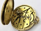 a gold pocket watch with a chain around it