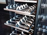 a wine rack with wine glasses on it in front of a refrigerator