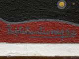 a painting of a black cat on a red and white wall