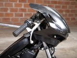 a black motorcycle parked in front of a brick wall