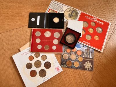 beaucoup de pièces de monnaie posées sur une table, à côté d'un livret