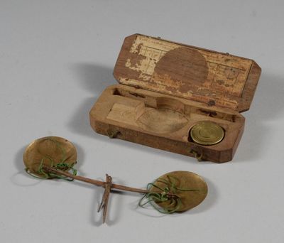 a small wooden box with a wooden spoon and a pair of gold spoons