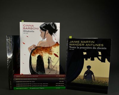two books are sitting on a table in front of a black background