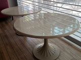 two tables that are sitting in front of a window