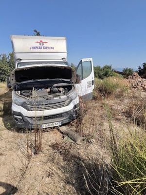 un camion blanc dont le capot est ouvert, garé sur le bord de la route