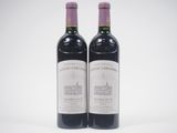 two bottles of wine sitting next to each other on a white surface