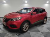 une voiture rouge garée dans un garage au sol en damier
