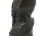 a black sculpture of a man ' s head on a white surface