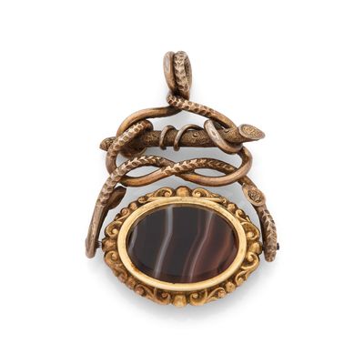 un gros plan d'un pendentif sur lequel est représenté un serpent, vu de dos