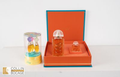 une boîte orange contenant deux flacons de parfum et un pot