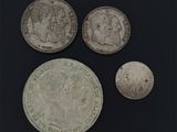 On voit trois pièces d'argent sur une surface noire