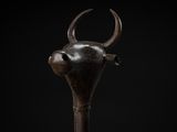 a close up of a wooden stick with a bull head on it