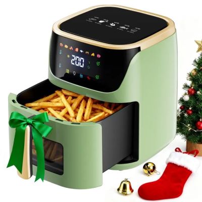 une friteuse à air chaud contenant des frites, à côté d'un sapin de Noël