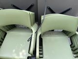 two green chairs sitting next to each other on the ground