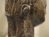 sculpture of a woman ' s head on a pedestal in front of a white wall