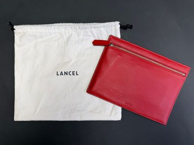 a red and white bag and a red wallet on a table