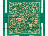 une écharpe carrée verte et dorée, ornée d'oiseaux et de fleurs