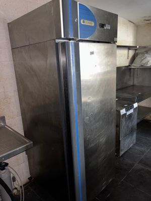 a stainless steel refrigerator in a kitchen with a bicycle parked in front of it