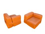 pair of orange leather lounge chairs with matching footrests
