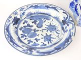 a blue and white plate and a blue and white vase on a table