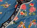 an image of a blue jacket with colorful flowers and birds on it