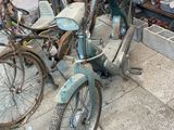 un vélo garé sur le trottoir devant une voiture