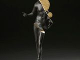 une statue en bronze d'une femme avec un chapeau sur la tête