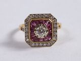 a close up of a pink and white diamond ring on a white surface