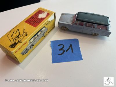une petite voiture miniature posée à côté d'une boîte sur laquelle est collé un autocollant