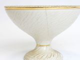 a white bowl with a gold rim sitting on a white surface