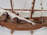 a wooden model of a boat on display on a white surface