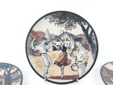 three plates with a painting on them sitting on a table