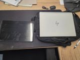a laptop and a tablet on a desk with a bag