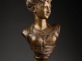 a bronze bust of a woman wearing a necklace