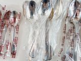 a lot of silver spoons and spoons wrapped in plastic