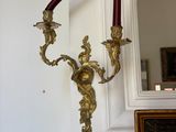 two candles that are on the wall next to a mirror