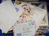 many letters and envelopes in a blue bin