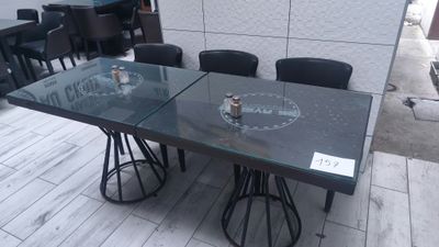 a glass table with chairs around it on the floor