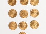 plusieurs pièces d'or disposées en forme de cœur sur un fond blanc