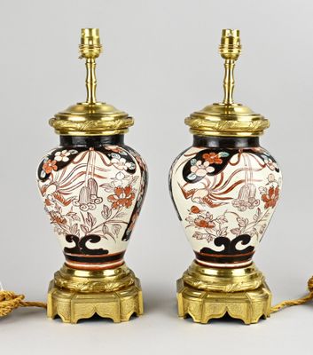 une paire de lampes de style oriental avec des pieds dorés et des motifs floraux