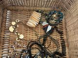 un panier en osier rempli d'un assortiment de colliers et de bracelets