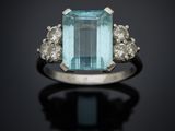 une bague sertie d'une aigue-marine et de diamants sur un fond noir