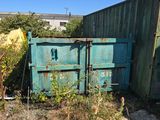 a blue dumpster sitting in a yard next to a fence