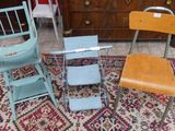 trois chaises et une table dans une pièce où se trouve un tapis