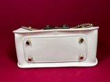 a white purse sitting on top of a red surface