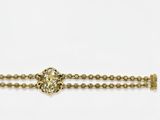 a close up of a gold bracelet with a cross on it