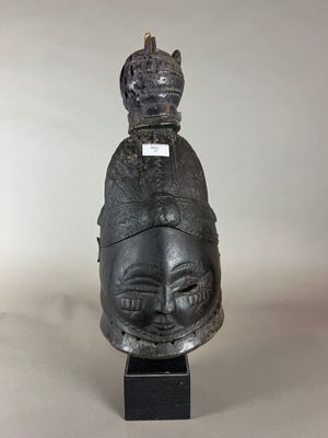 une sculpture noire représentant une tête surmontée d'une couronne