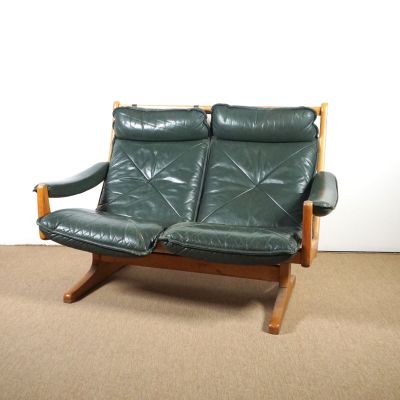 un canapé en cuir vert posé sur un sol recouvert de moquette